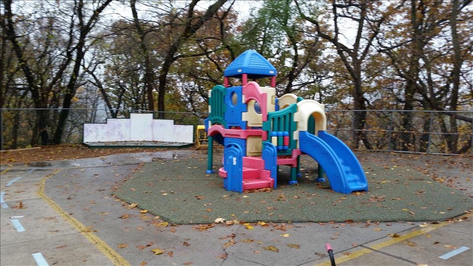 Colorful playground structure with slides and climbing areas on a fall day