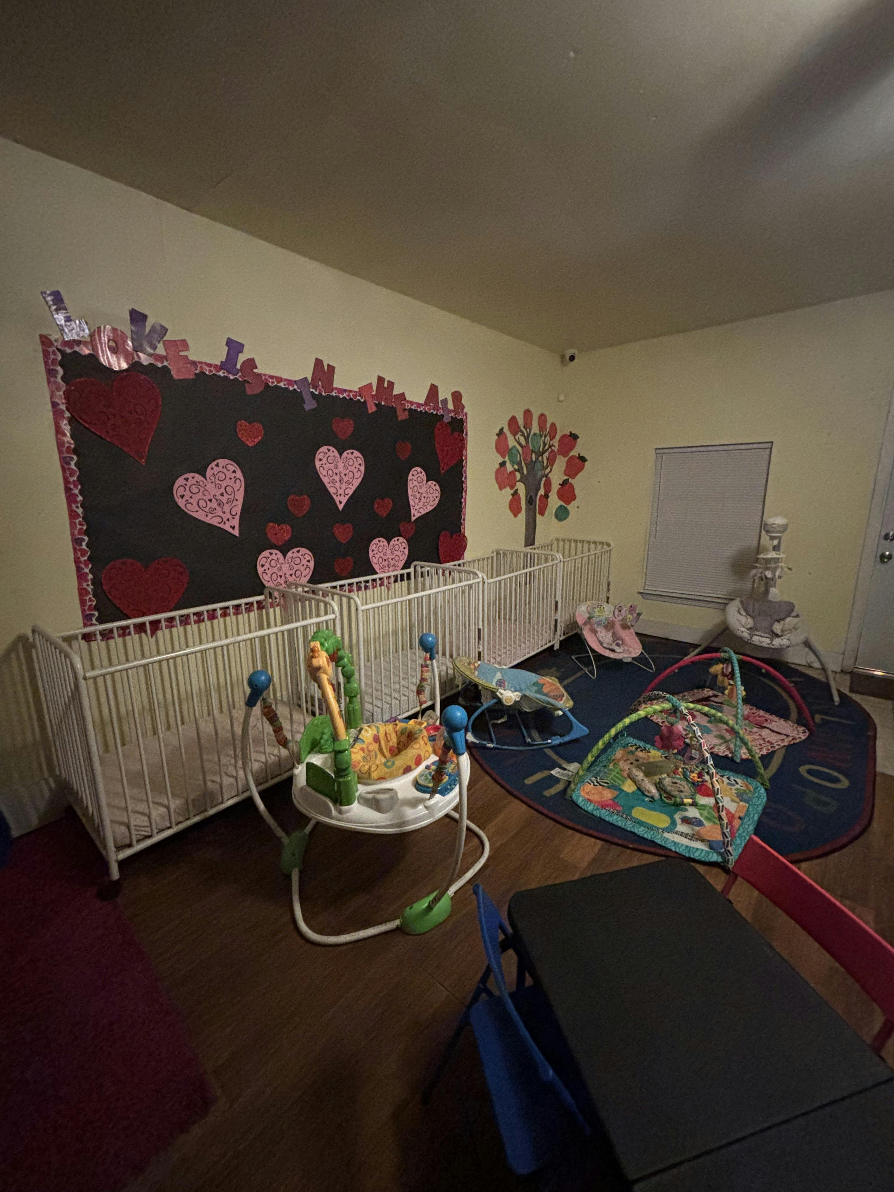 Baby room with cribs, playmats, and bouncing chairs