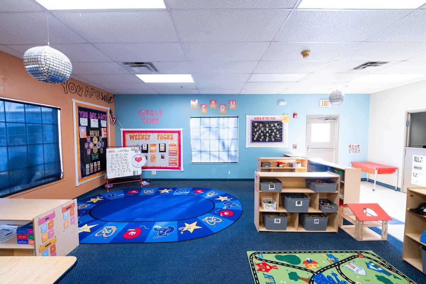 Colorful preschool classroom with circular area rug and storage shelves