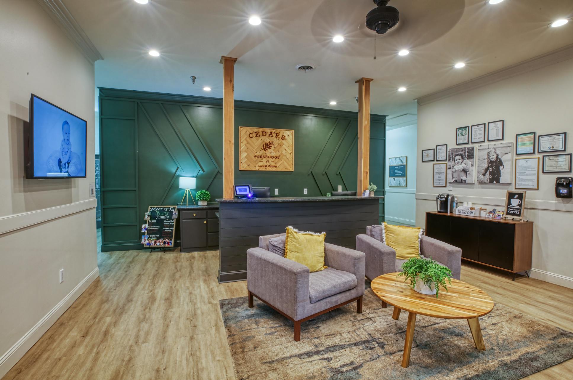 Reception area with a desk, two armchairs, a coffee table, and a TV