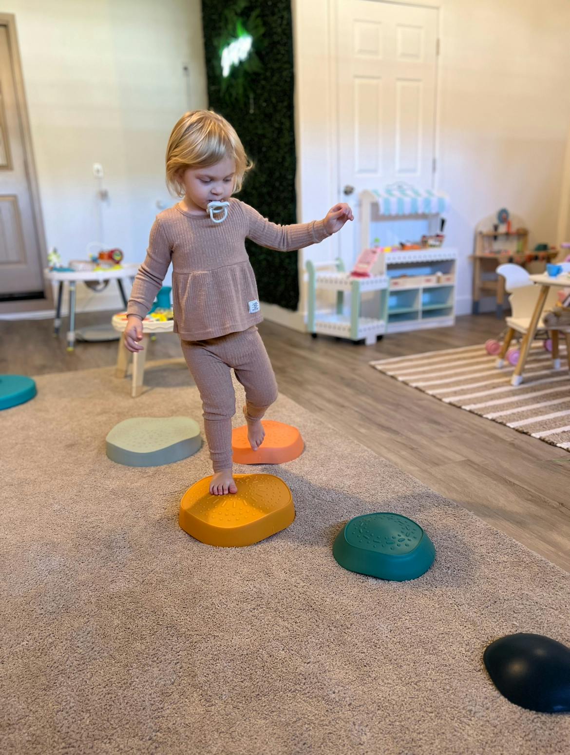 Child stepping on colorful balance pods