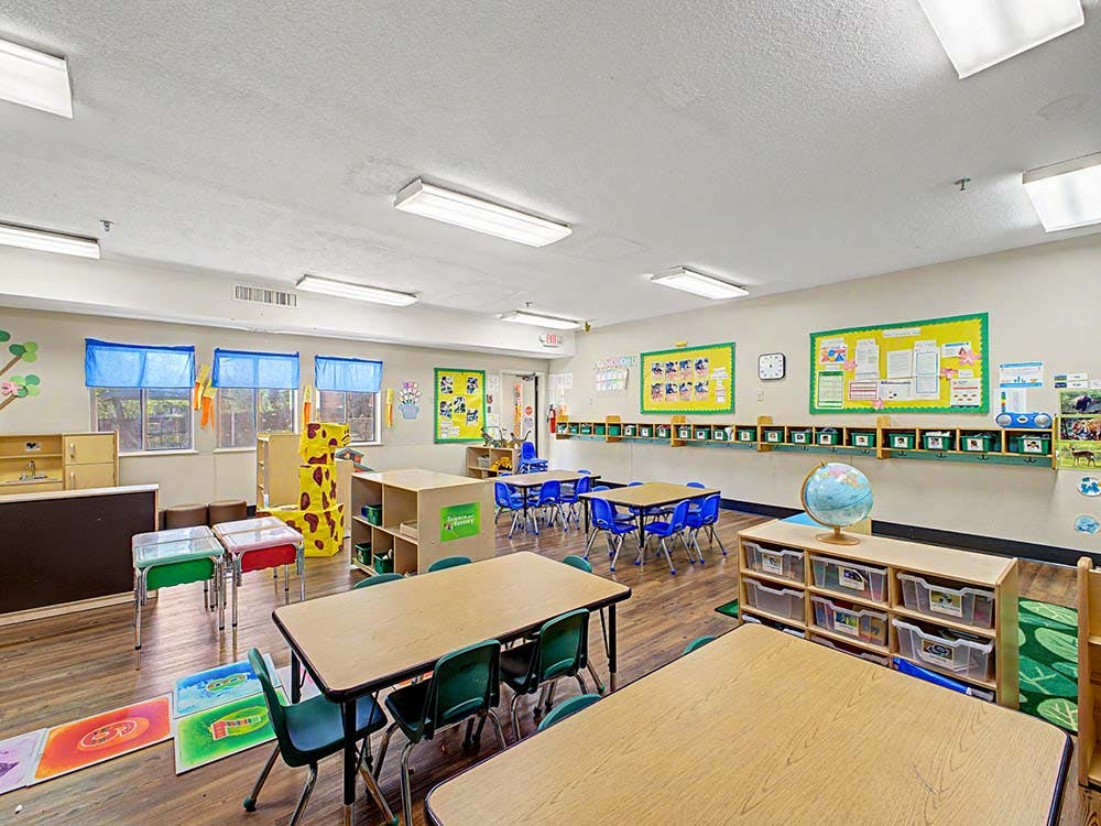 Classroom with small tables and chairs, bulletin boards, and learning materials