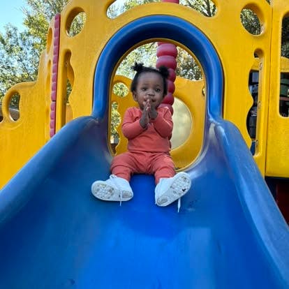 Child sitting on a playground slide
