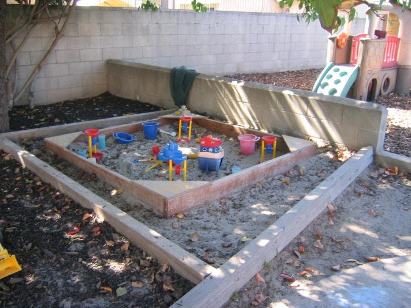 Sandbox with colorful toys in a backyard