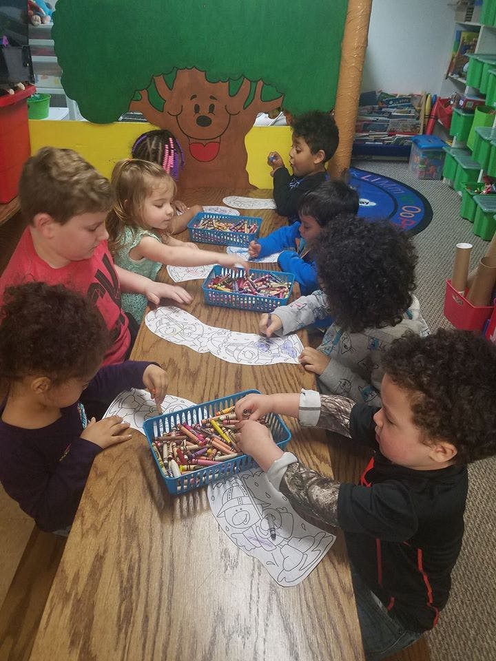 Children coloring at a table in a classroom