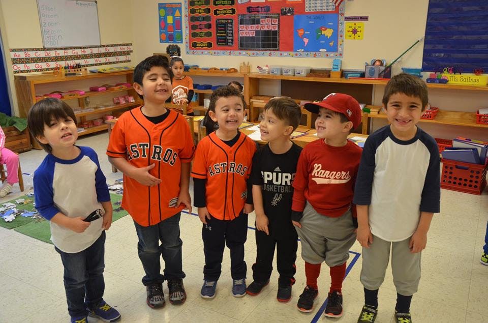 Group of children in baseball jerseys in a classroom