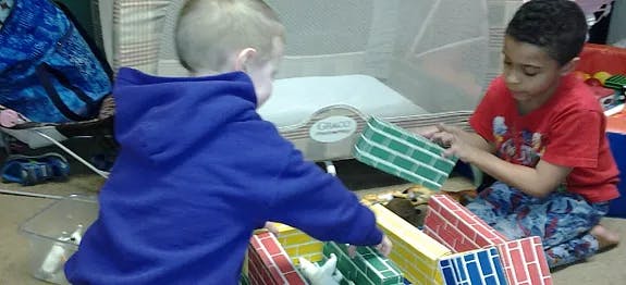 Two children playing with colorful blocks on the floor