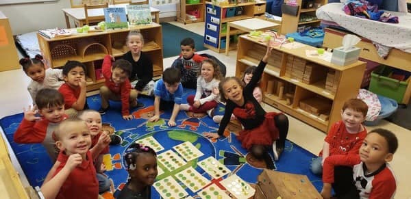 Group of children sitting on a rug in a classroom