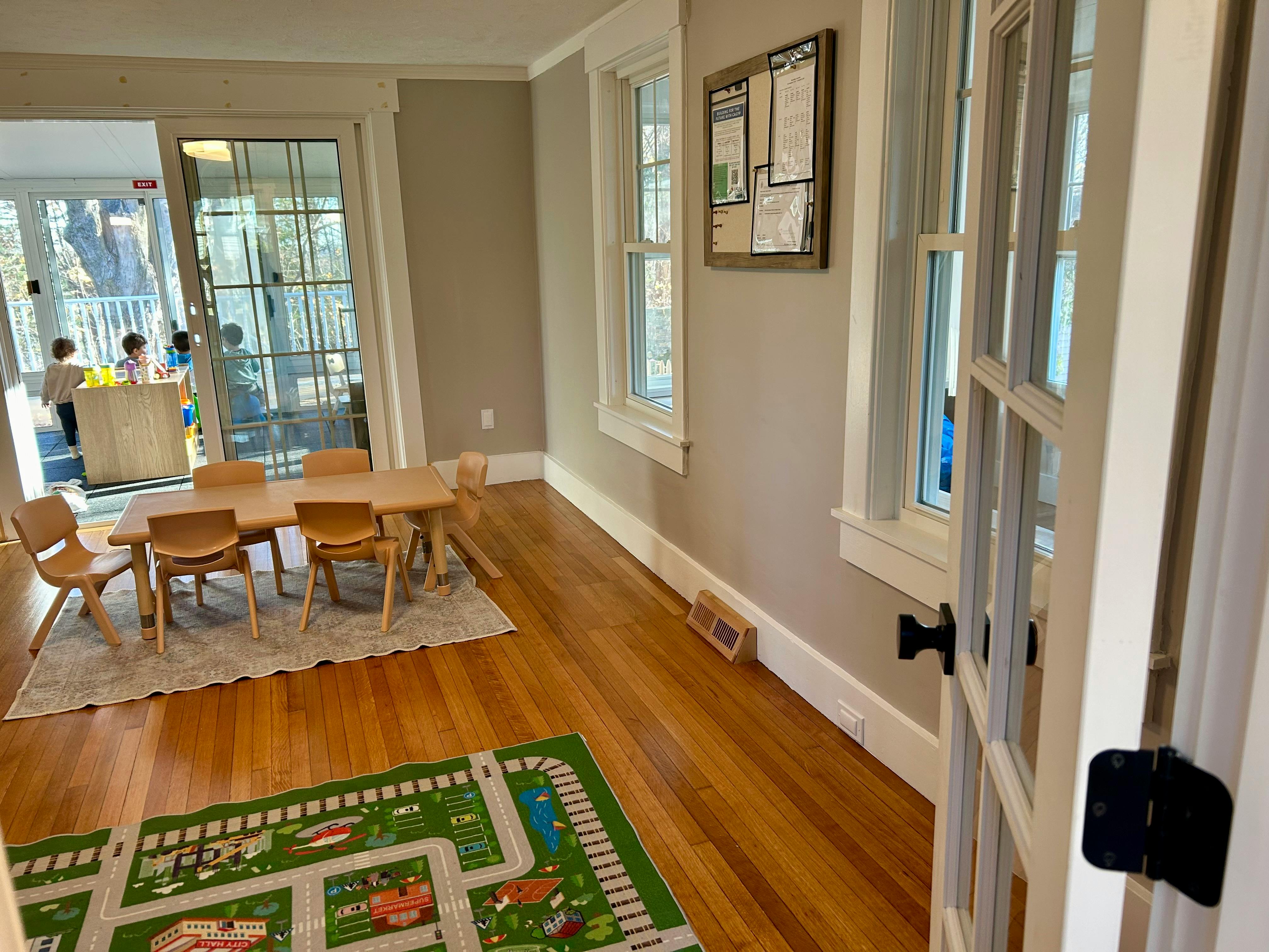Children's play area with small table and chairs, and a road map rug