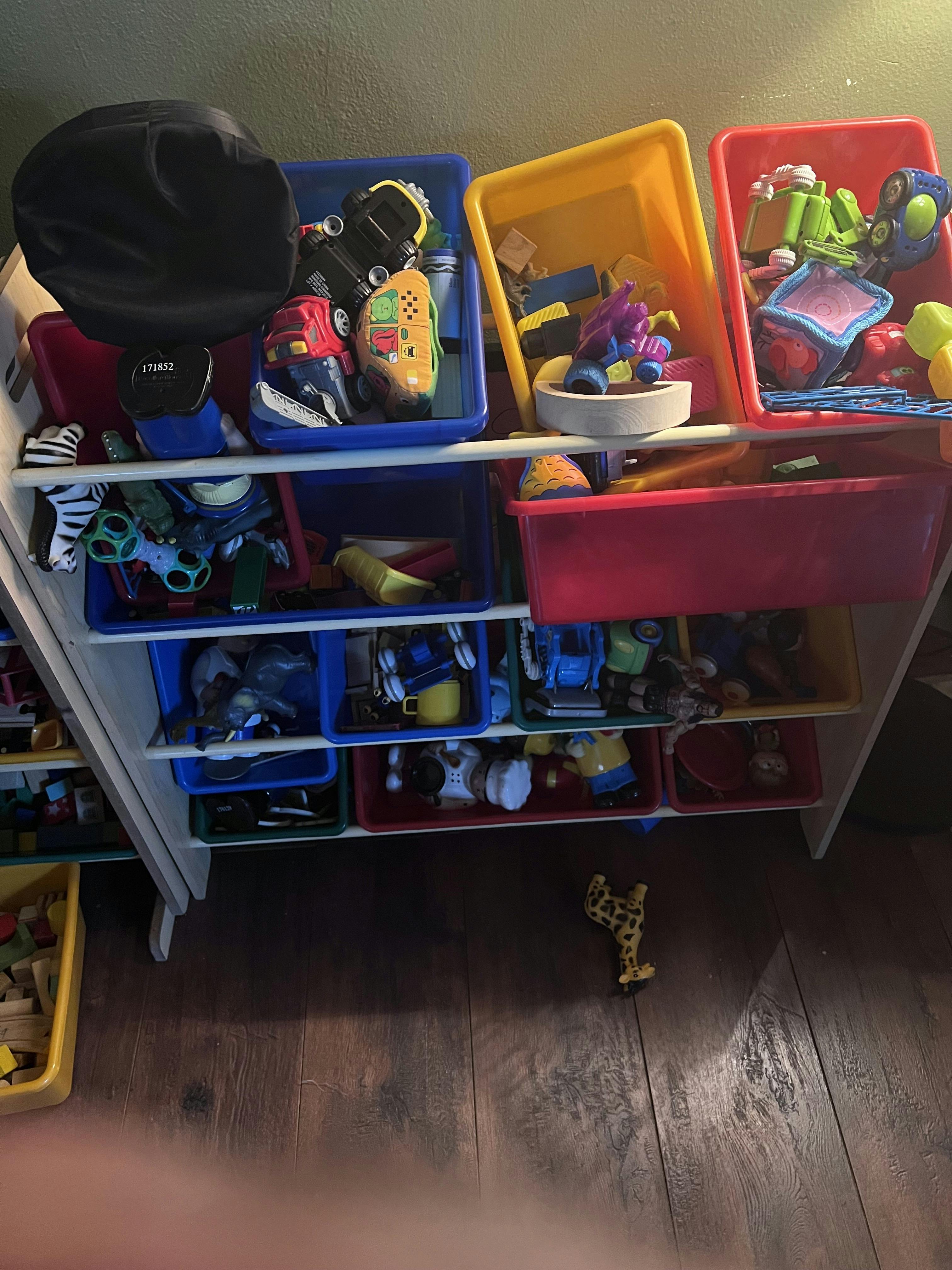 Toy storage unit with colorful bins full of various toys