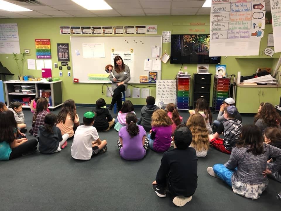 Person teaching children sitting on the floor in a classroom