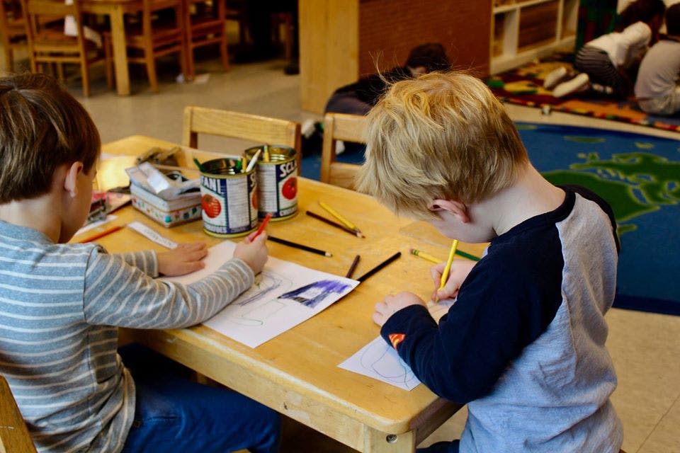 Two children drawing at a table