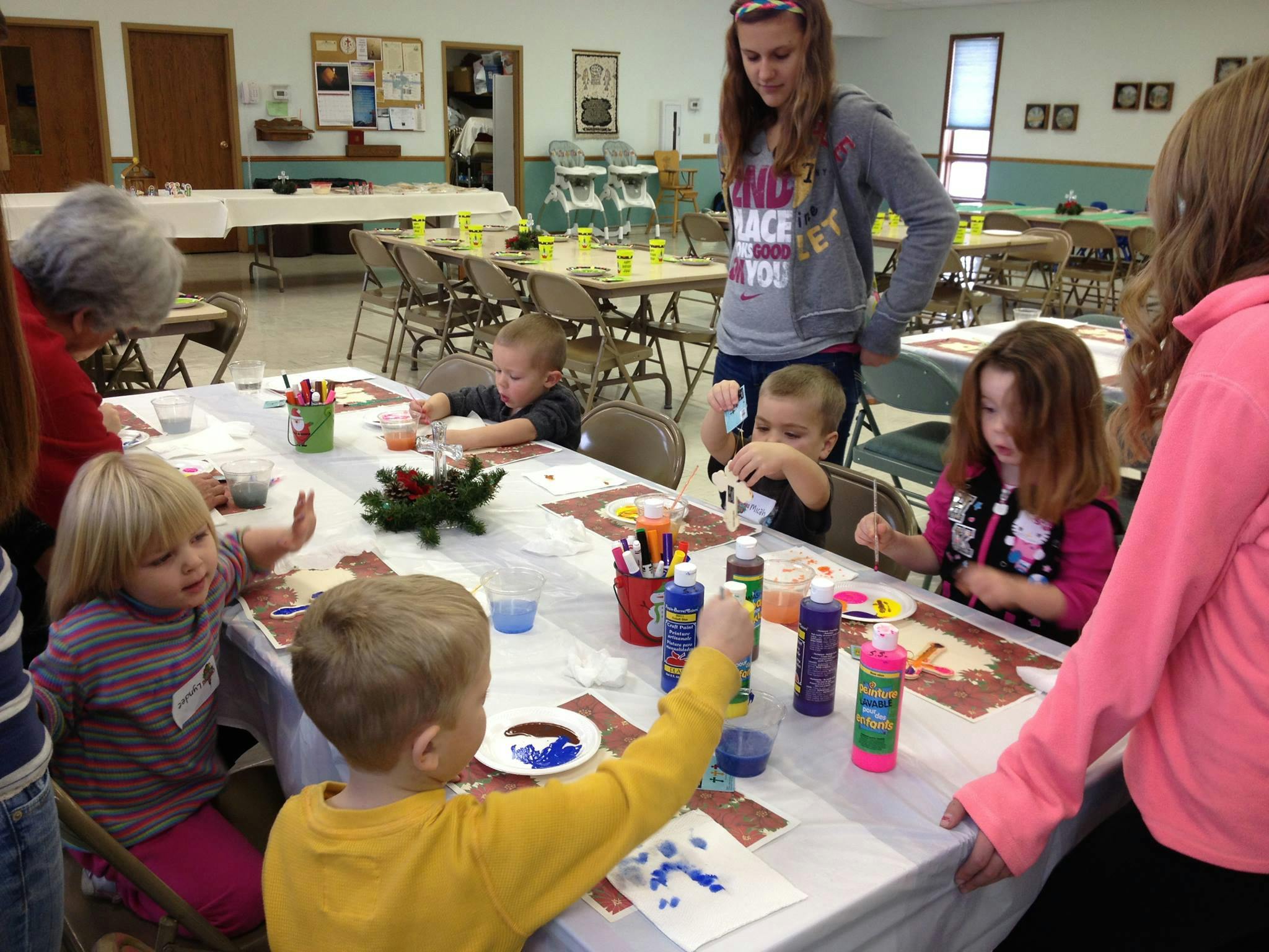 Adults and children painting at a table