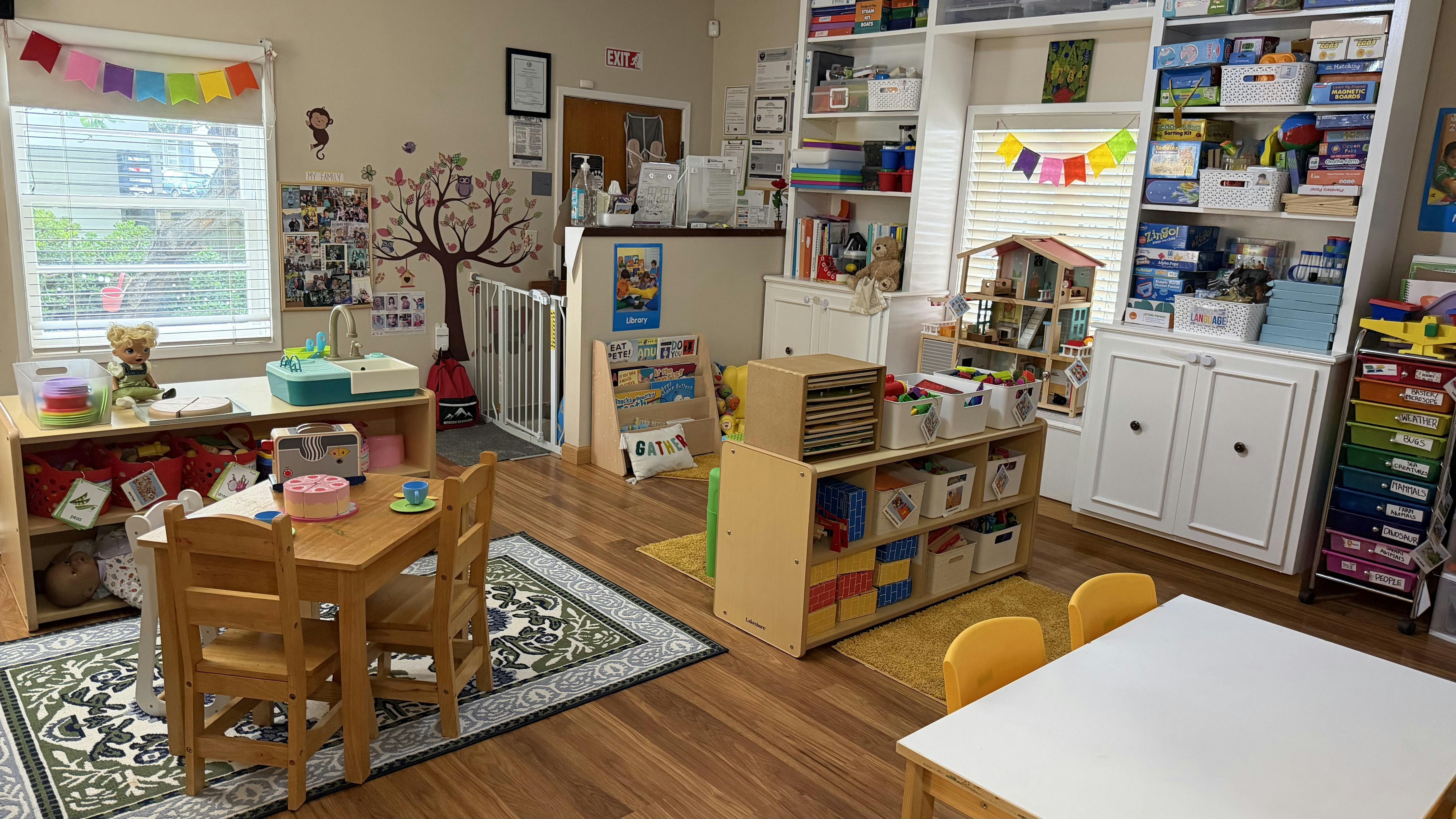 Classroom interior featuring child-sized furniture and shelving with toys