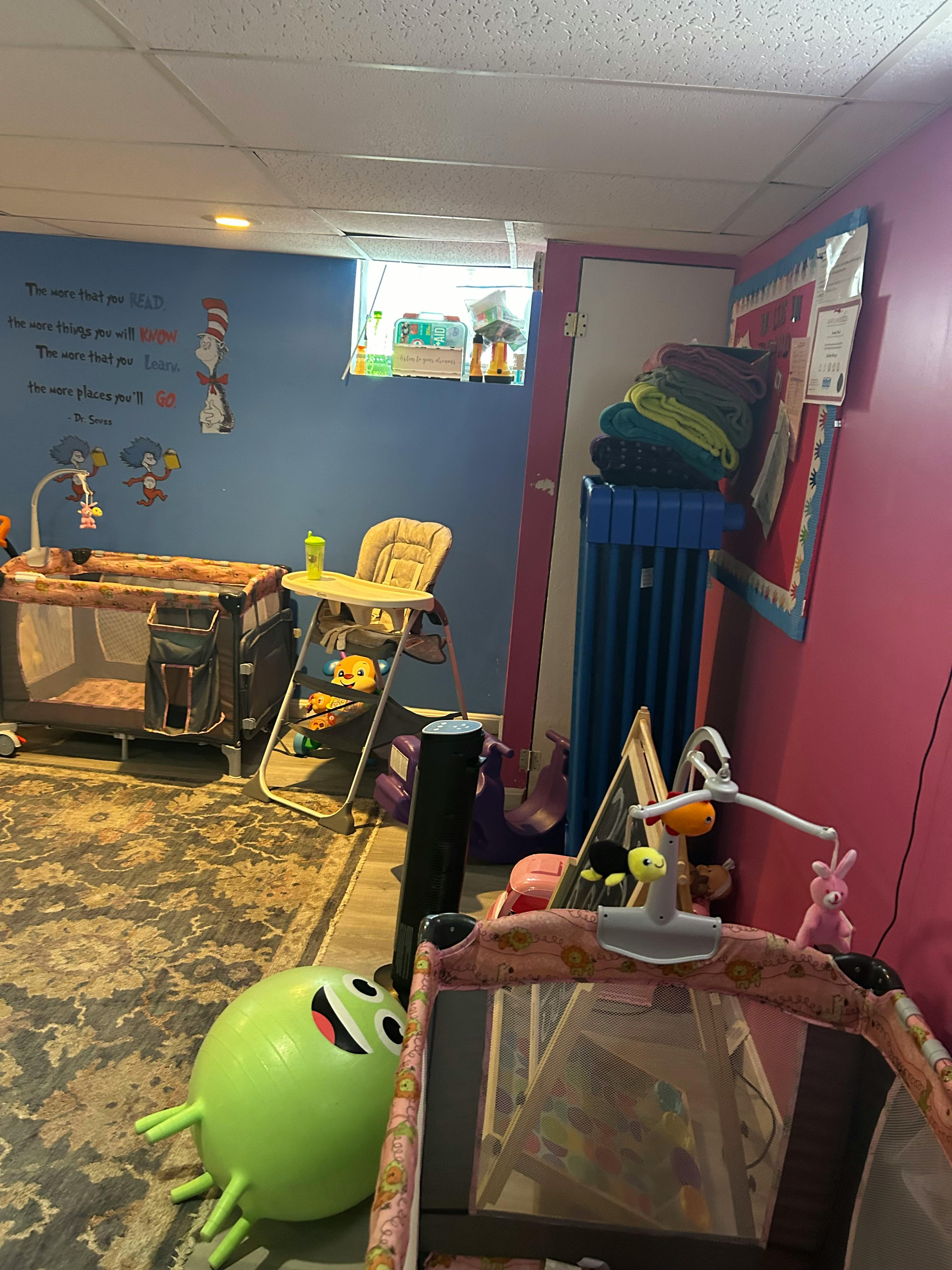 Nursery room with a crib, high chair, and playpen