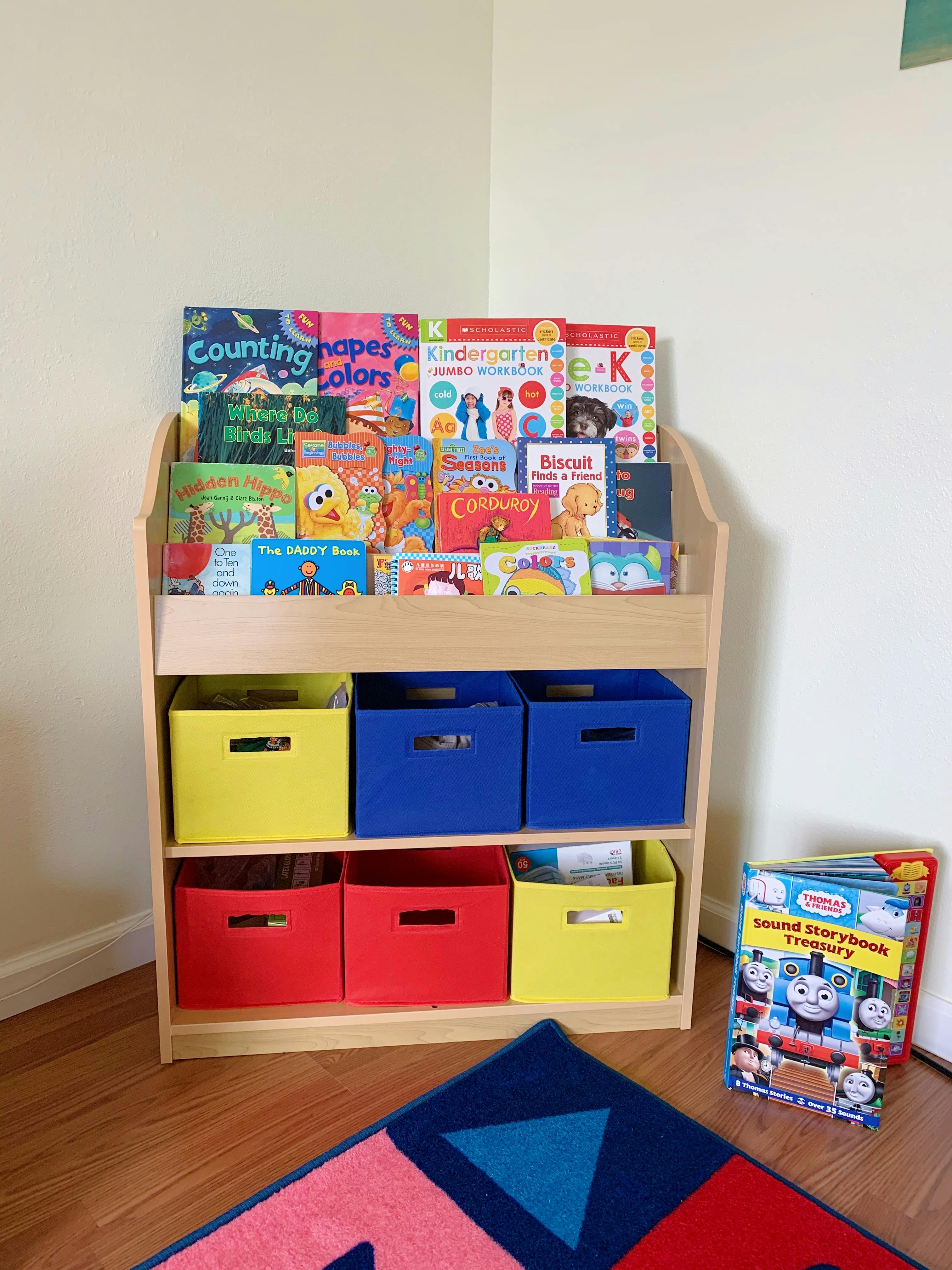 Children's bookshelf with books and colorful storage bins