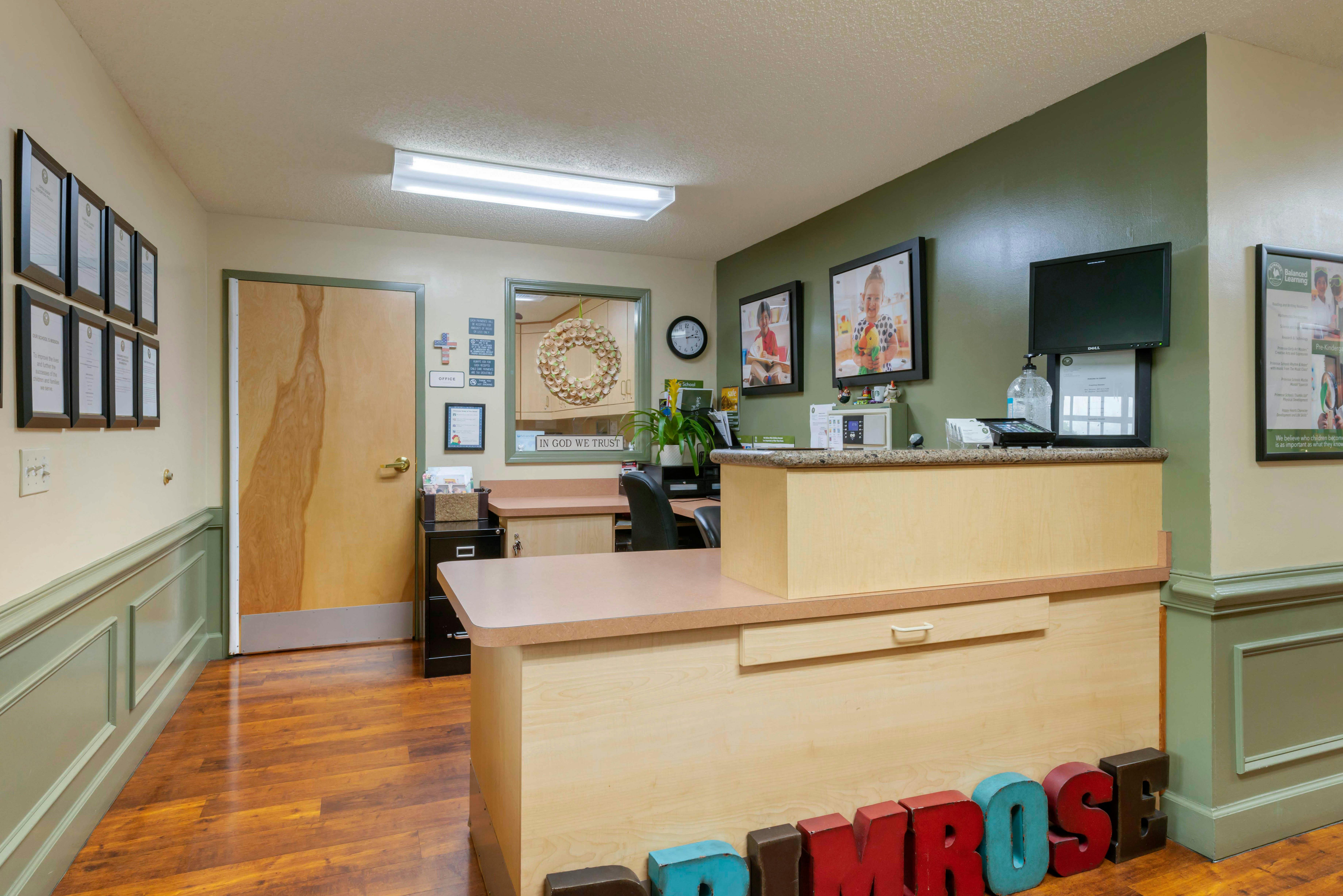 Reception desk with colorful letters spelling out "PRIMROSE" on the floor