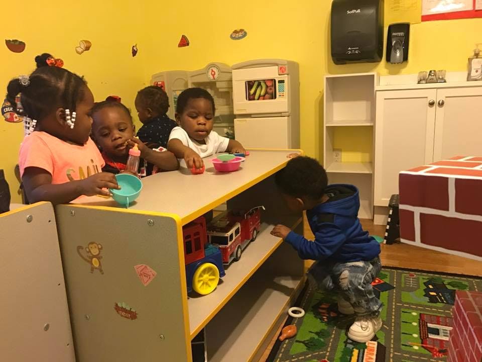 Children playing with toys at a table in a classroom