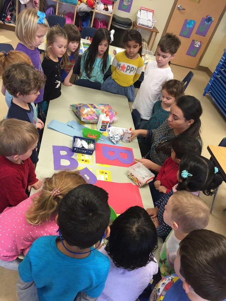 Adult and children gathered around a table with craft supplies