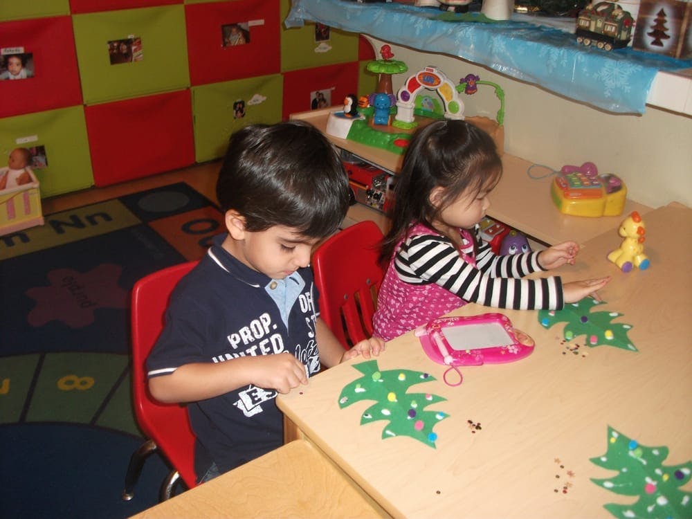 Two children sitting at a table in a classroom