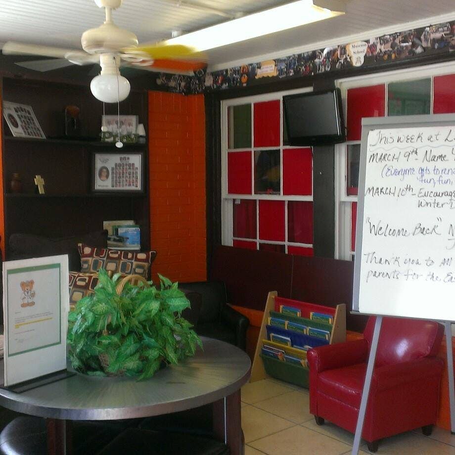 Room with a ceiling fan, whiteboard, and red chairs