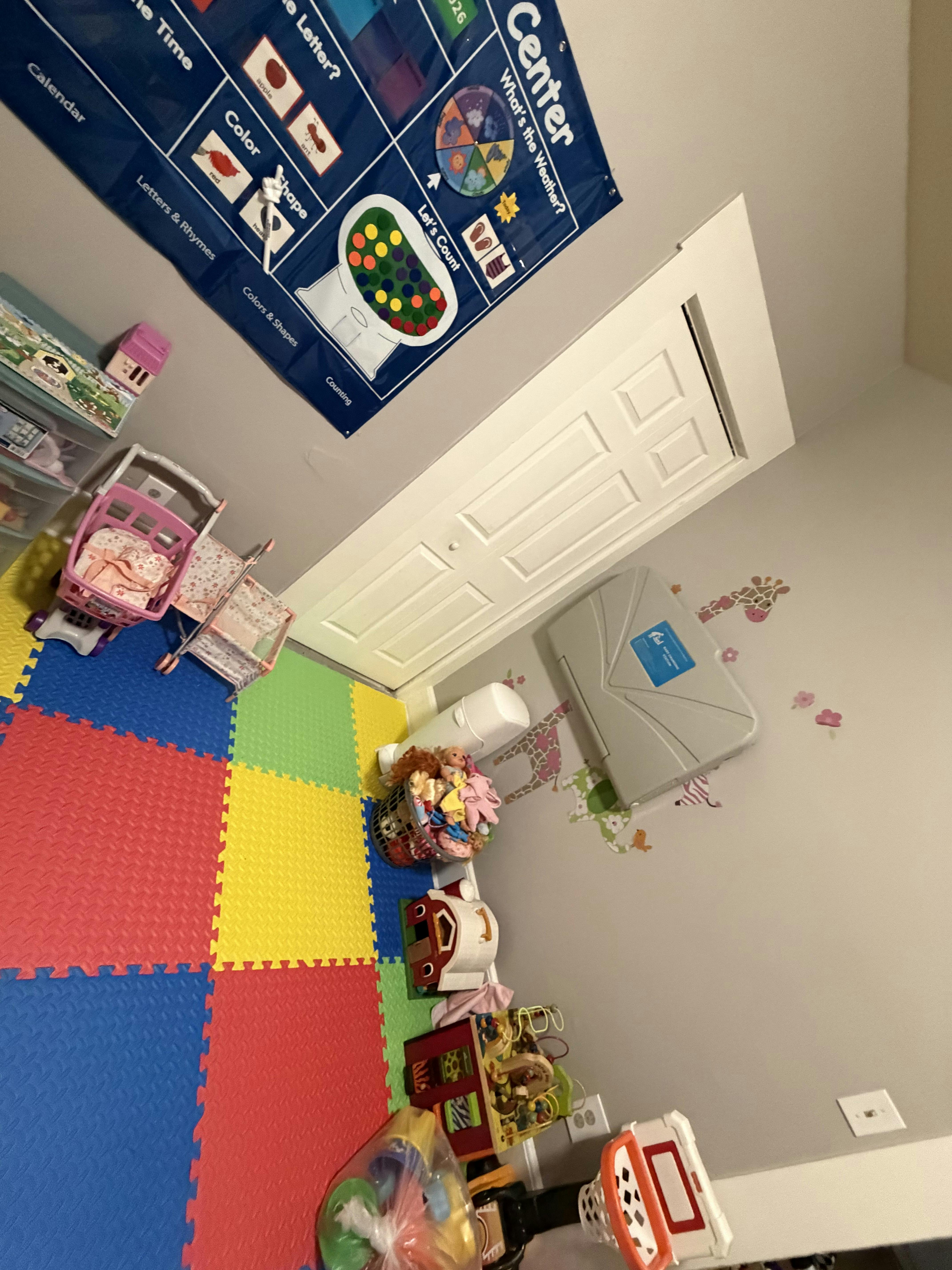 Play area with colorful floor mats and various children's toys