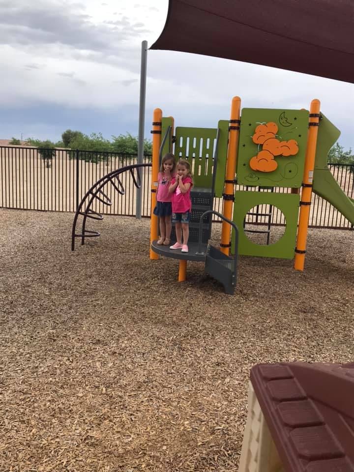 Two children standing on a playground structure