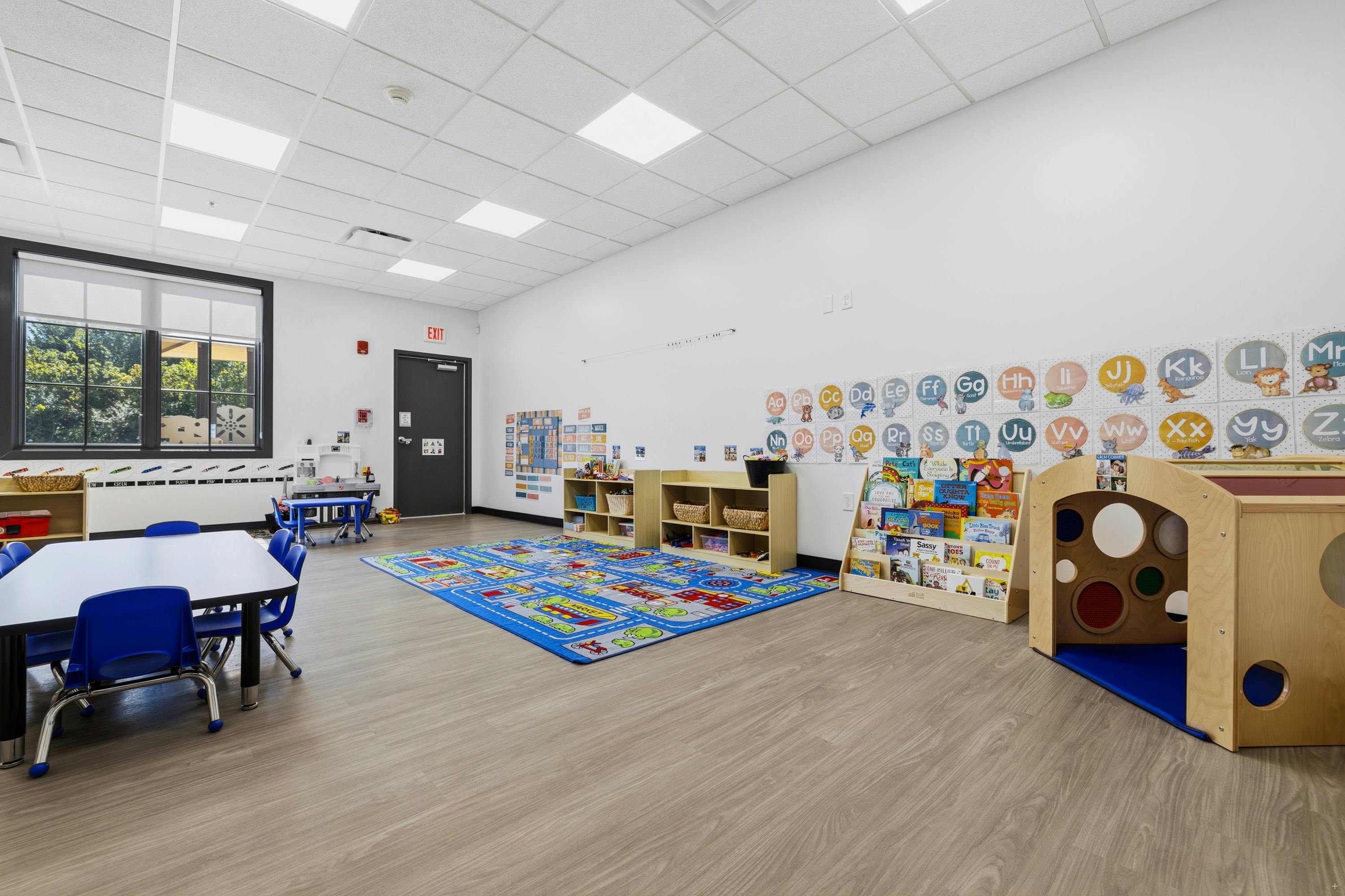 Classroom with child-sized furniture and a play rug