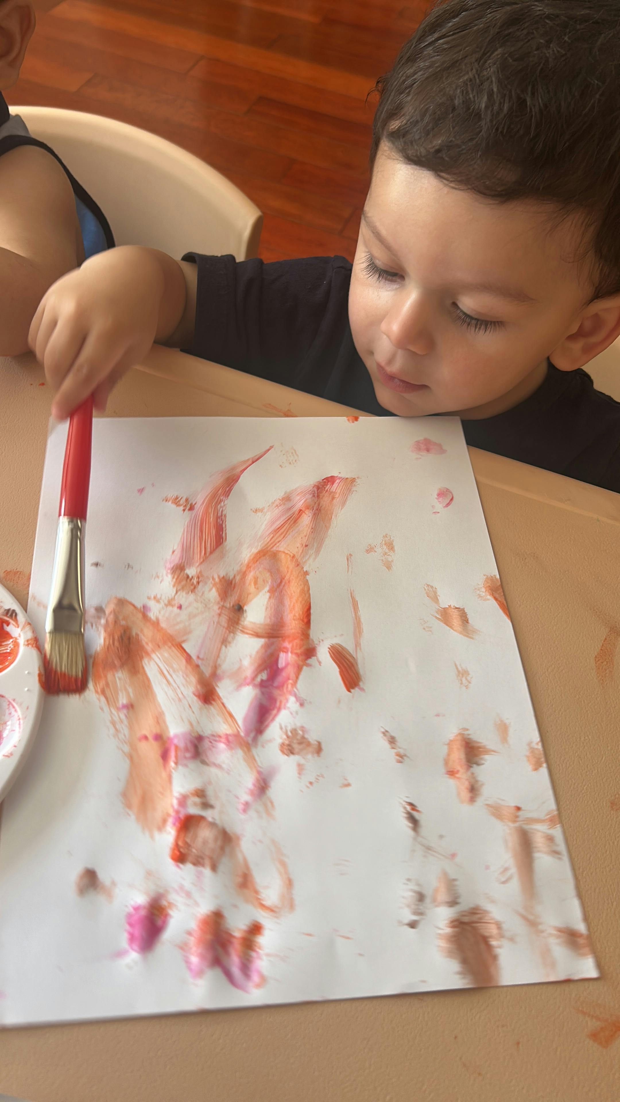 Child painting on paper at a table