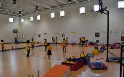 Children in a gymnasium with sports equipment