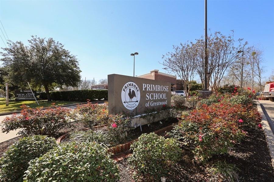 Primrose School of Gwinnett sign surrounded by bushes and trees