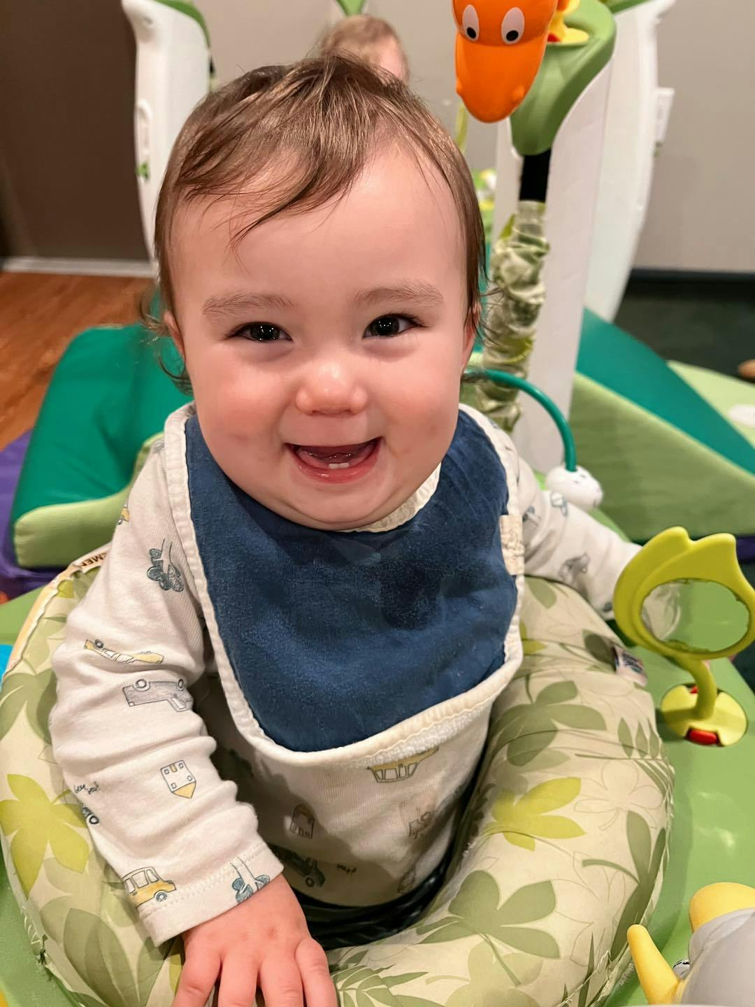 Child in a baby seat with a bib