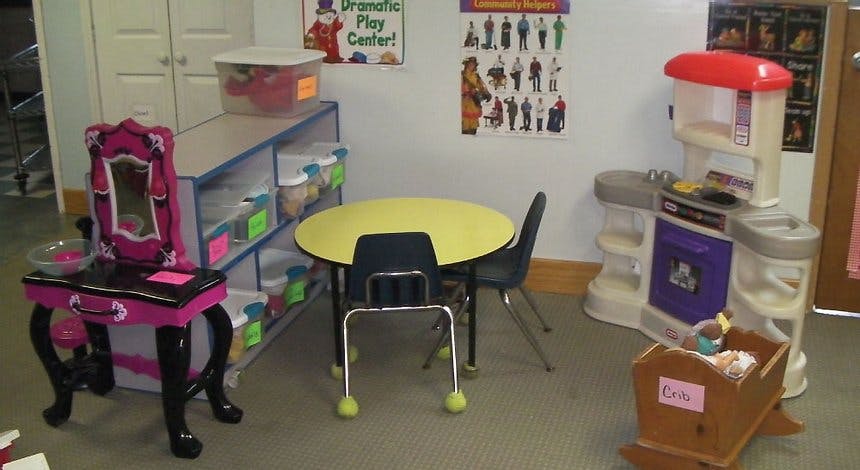 Playroom with toy vanity, table and chairs, and toy kitchen