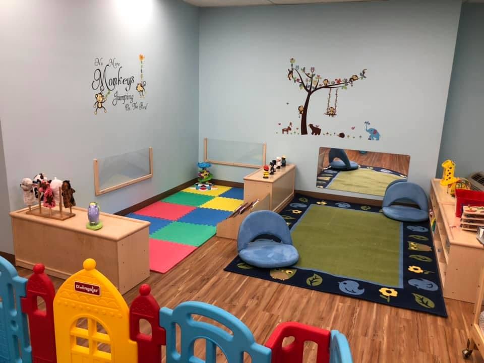 Playroom with colorful floor mats, small chairs, and wall decals