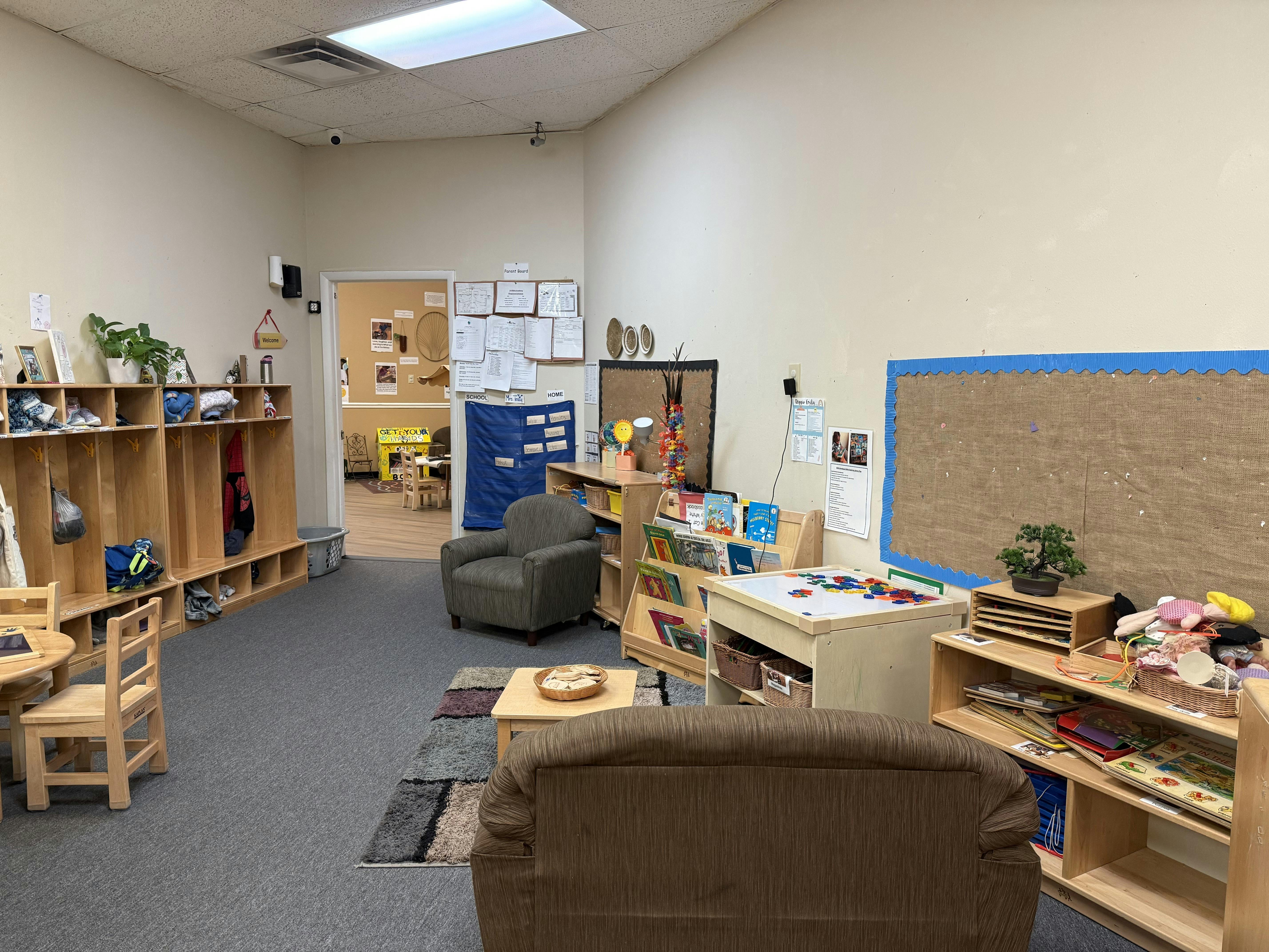 Classroom with cubbies, small tables, chairs, and a sofa