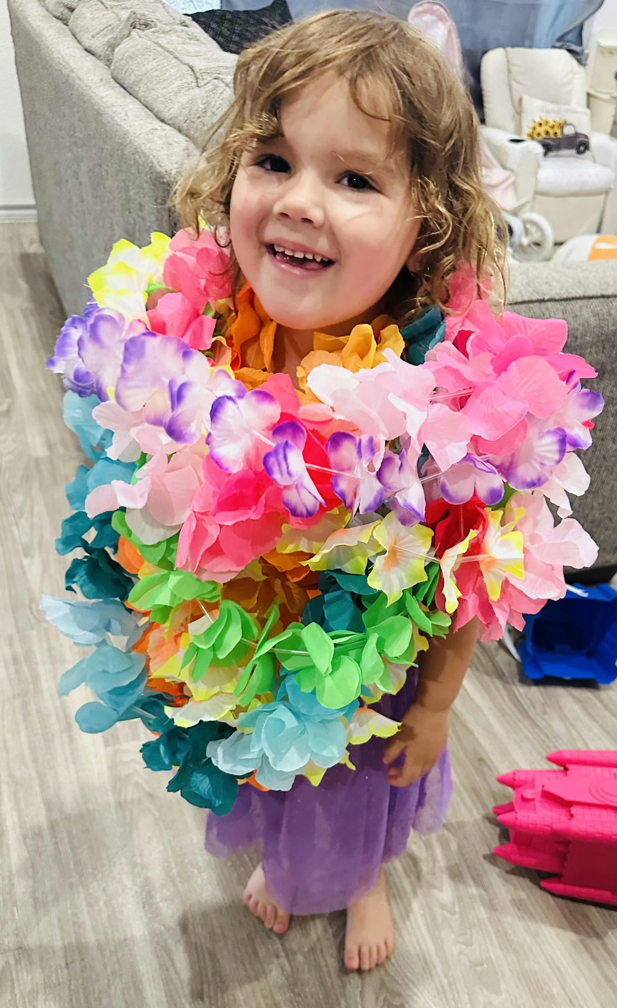 Child wearing multiple colorful flower leis