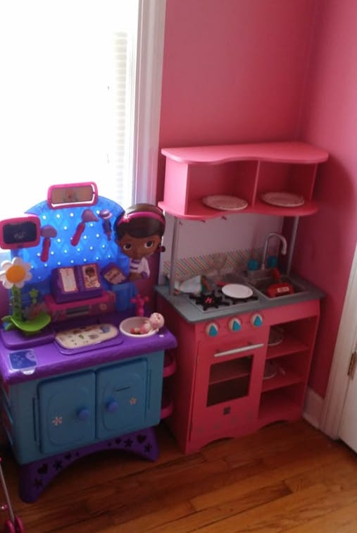 Two toy play sets, one a kitchen and the other a doctor's office