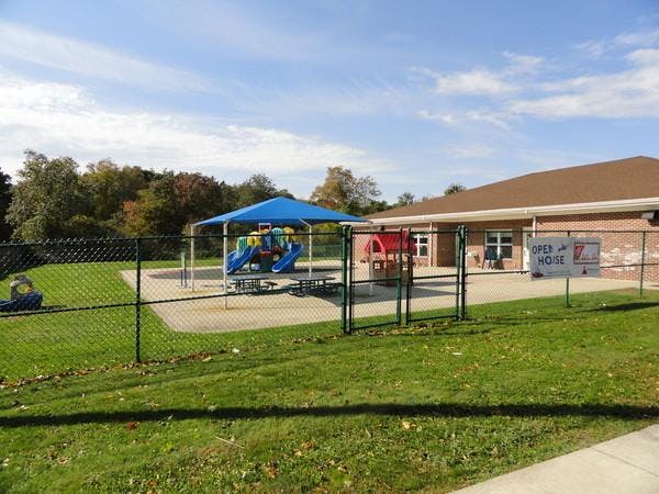 Playground with swings, slides, a covered area, and an "Open House" sign