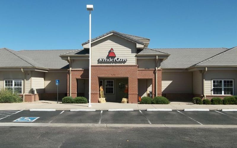 A beige and brick building with the "KinderCare" logo over the entrance