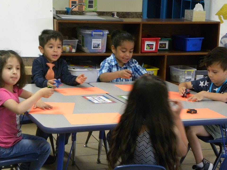 Children sitting at a table in a classroom