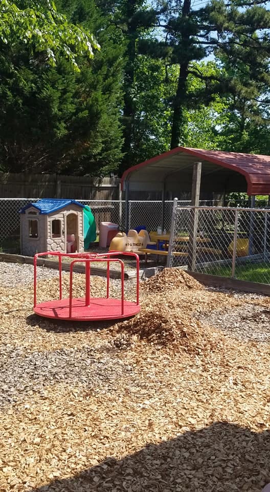 Red merry-go-round on wood chips in a playground