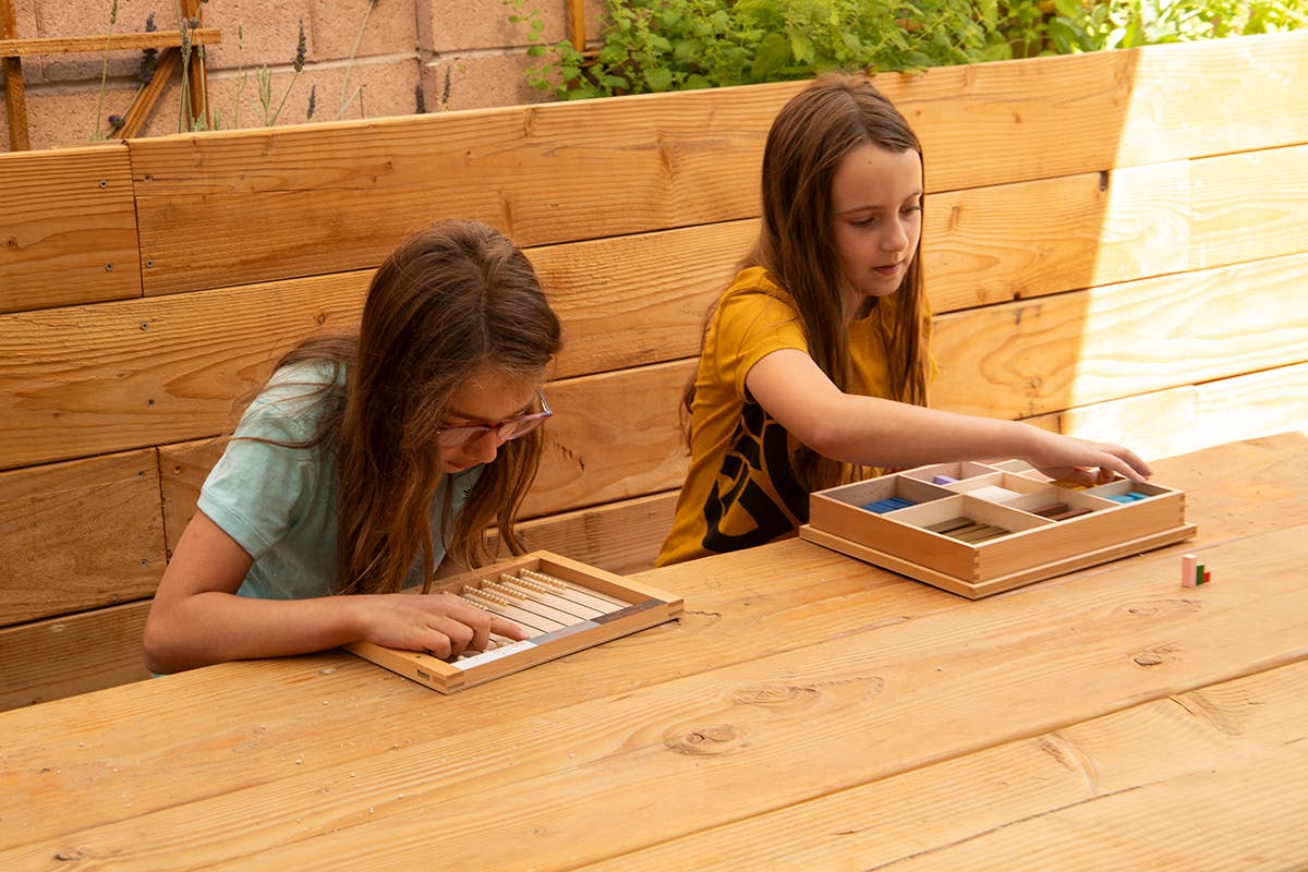 Two children playing with wooden educational toys at a table