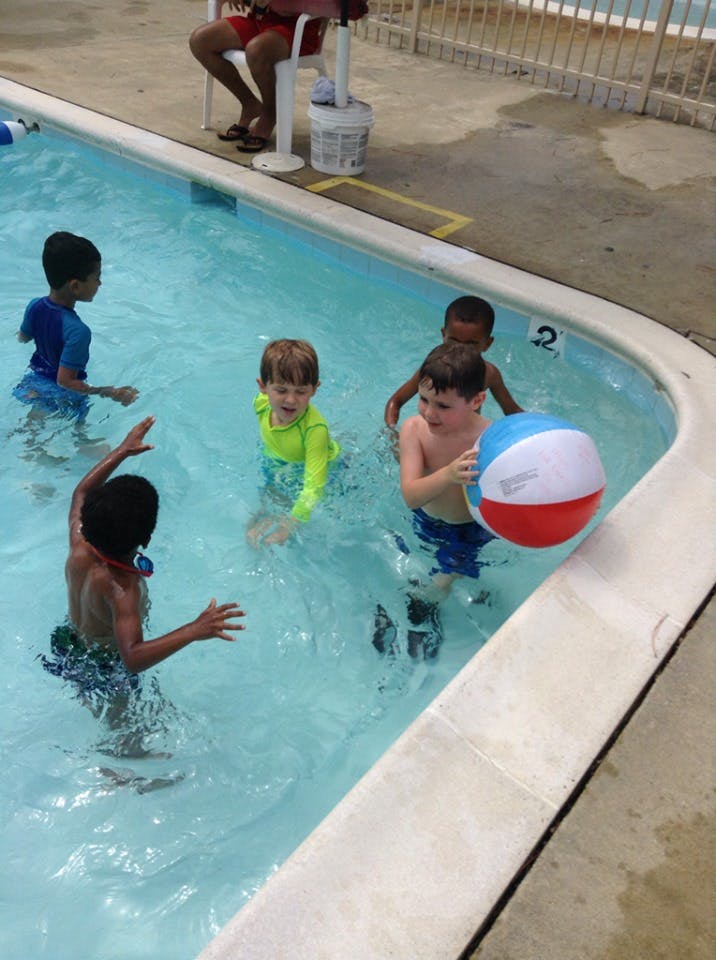 Children playing with a beach ball in a swimming pool