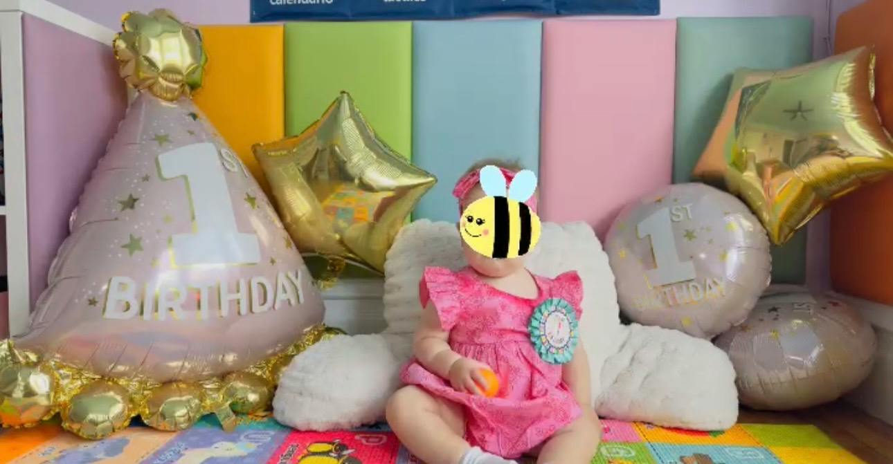 Child sitting in front of 1st birthday balloons