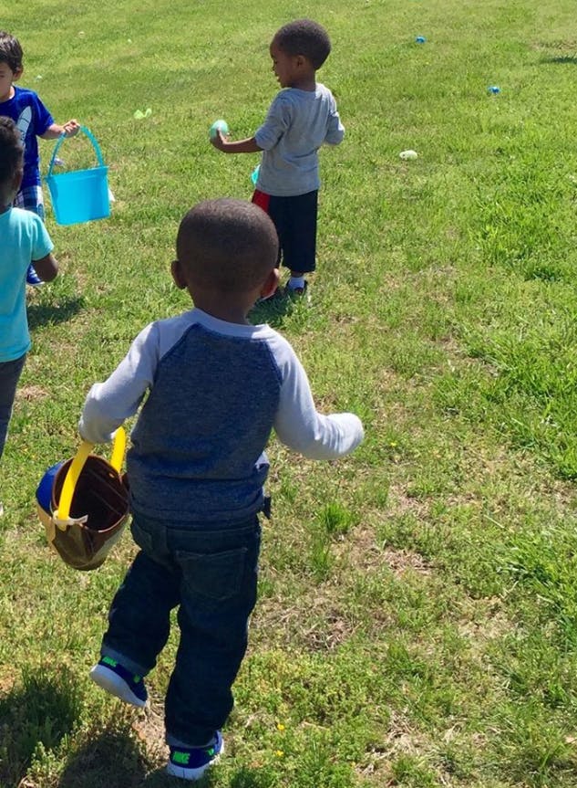Children on a grassy field with buckets