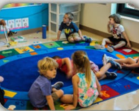 Children sitting on a colorful rug