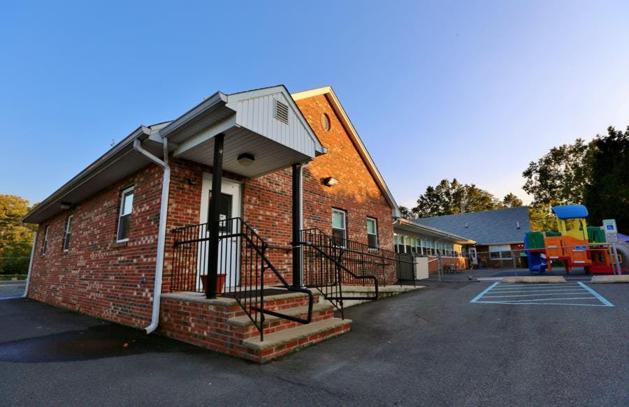 Brick building with a porch and a playground in the background