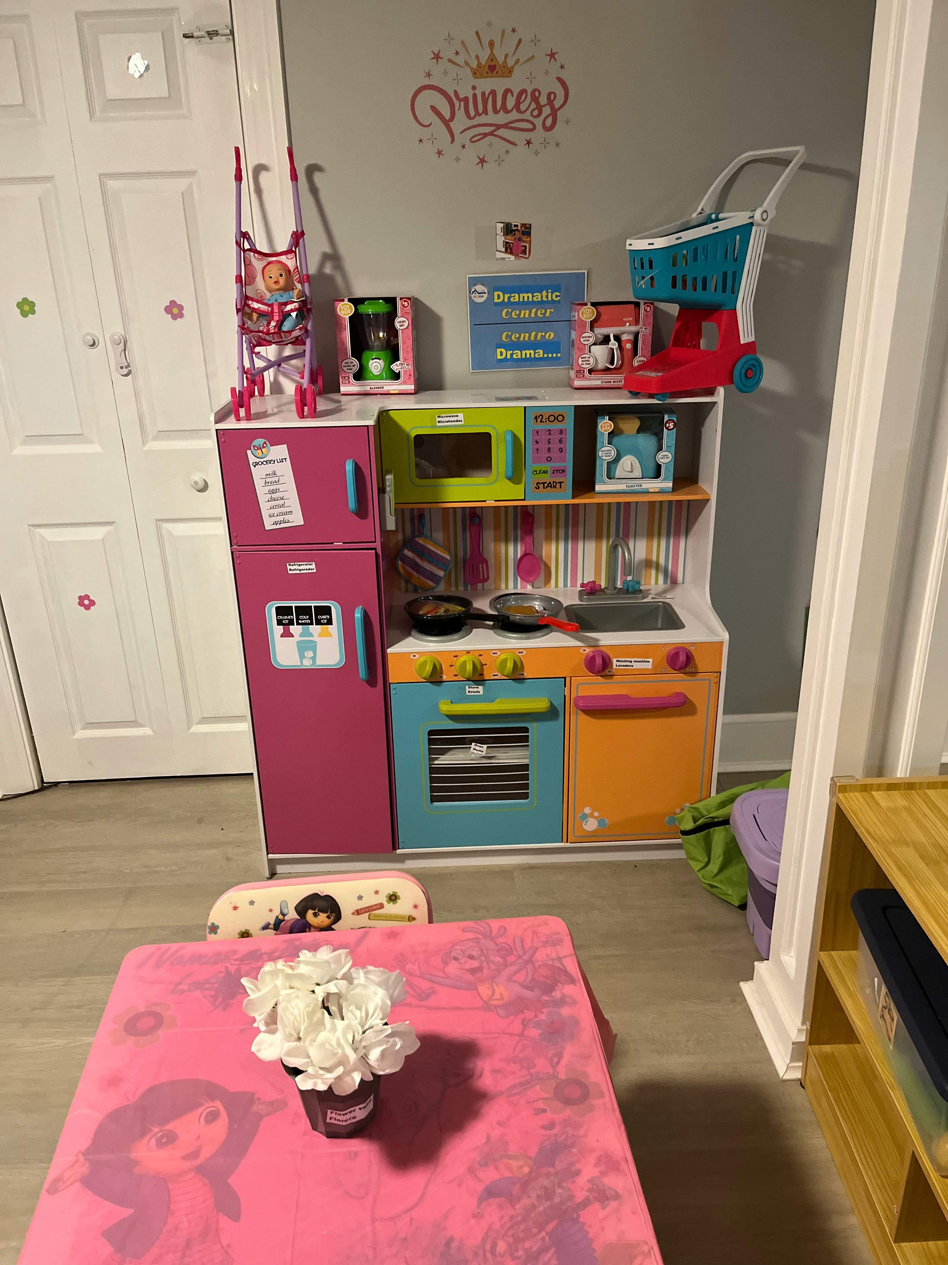 Child's toy kitchen set with a grocery list on the refrigerator