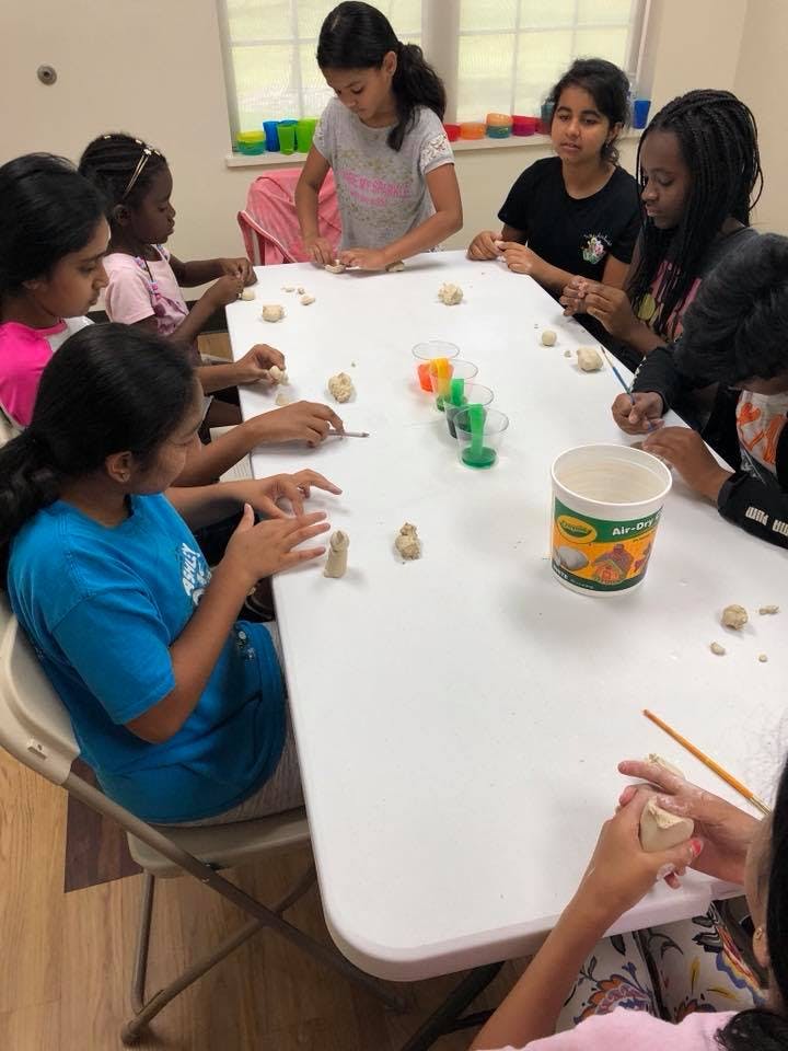 Children sitting around a table working with clay