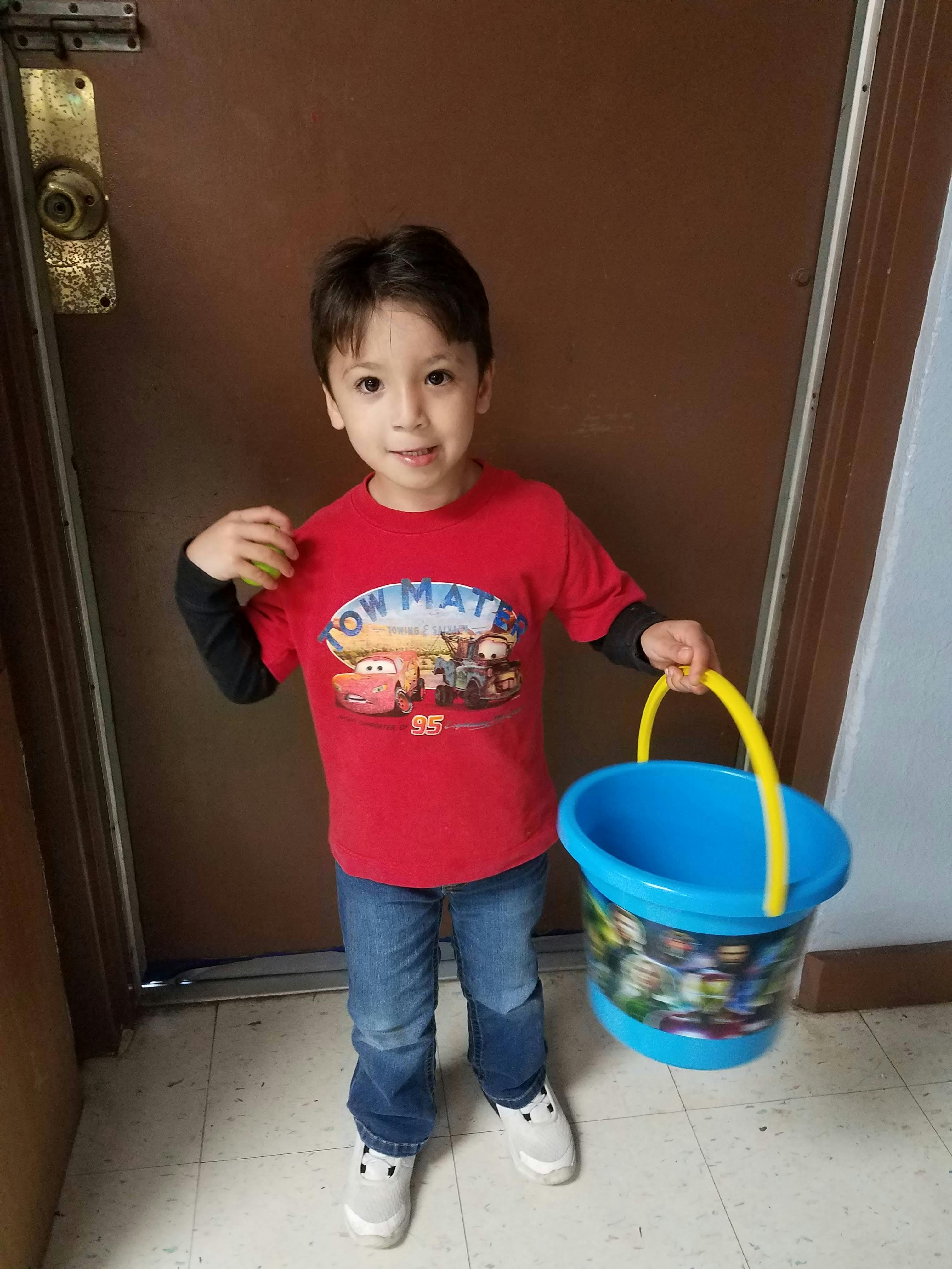 Child holding a blue bucket